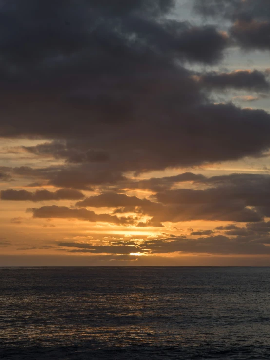 the sunsets are going down on the horizon of the ocean