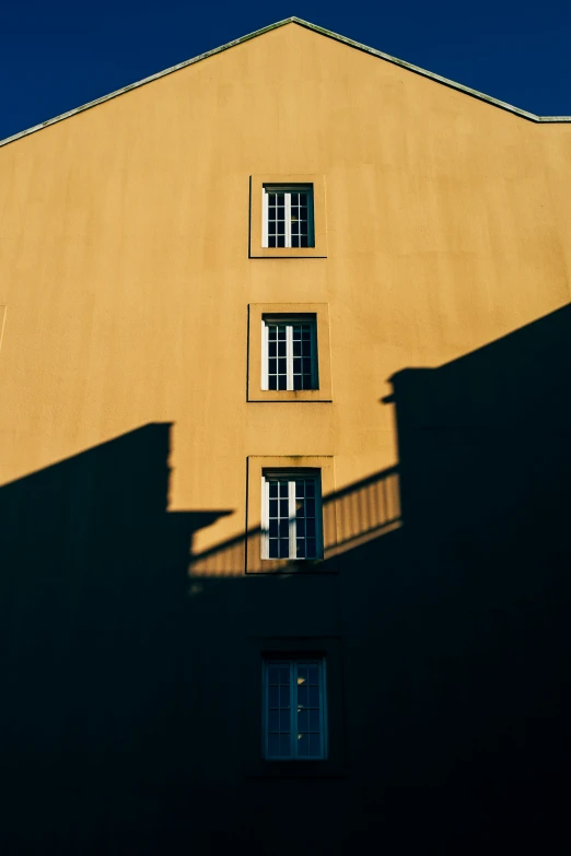 the shadows cast on the wall from windows and an iron staircase