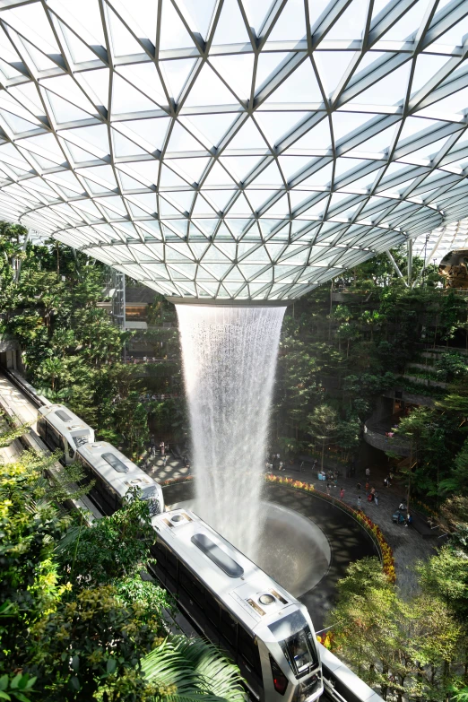 a view from inside a high - rise structure with water and a train coming down the track