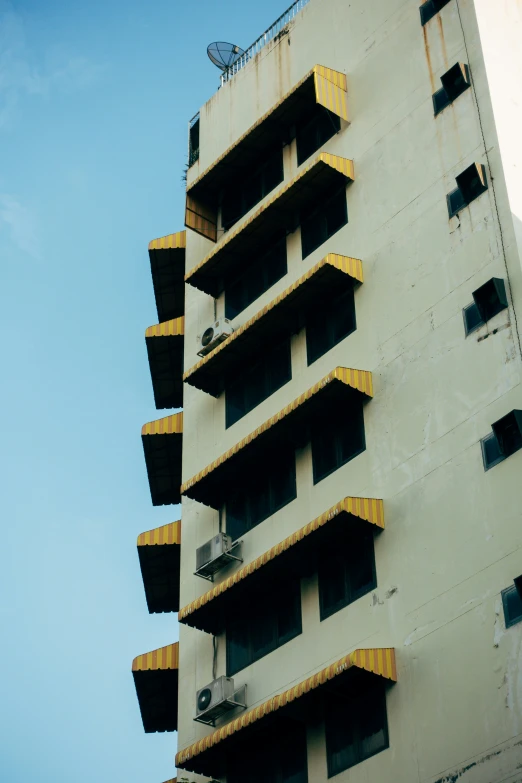 an apartment building with yellow balconies and several levels