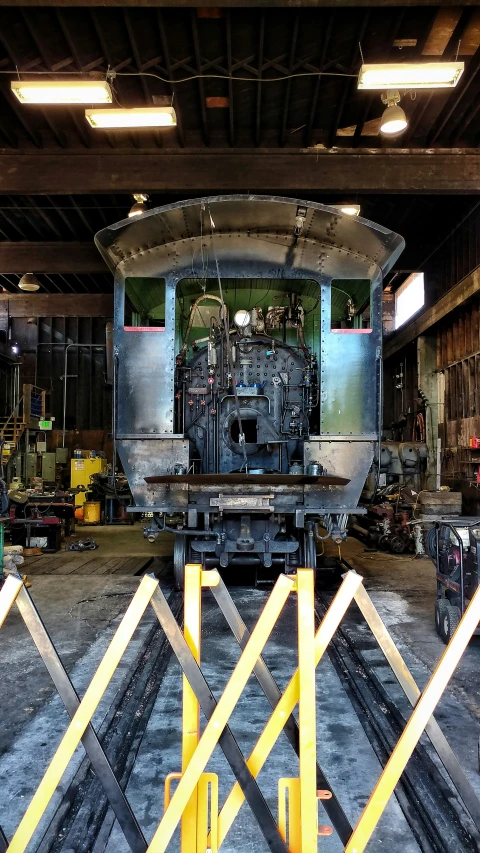 a train in the middle of a workshop on a metal track