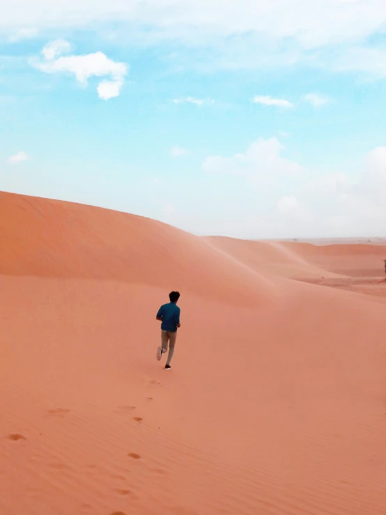 a man walking in the desert with a kite in his hand