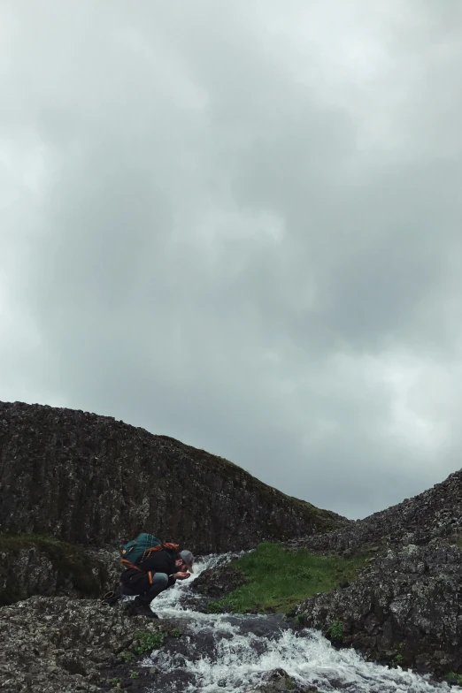 a man on a raft in the water next to rocks