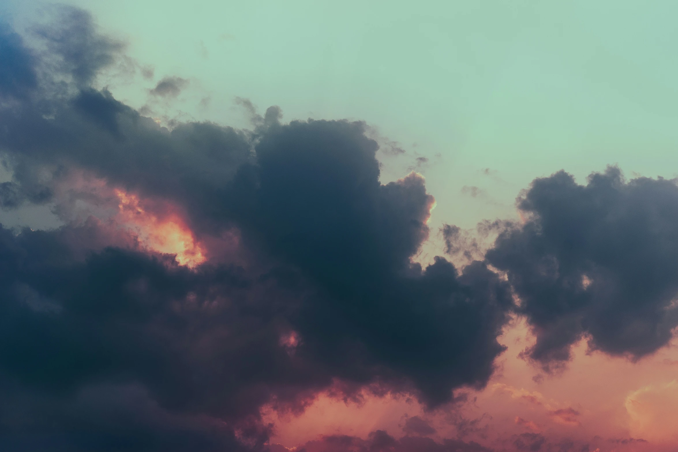 a plane flying through a cloudy sky at dusk