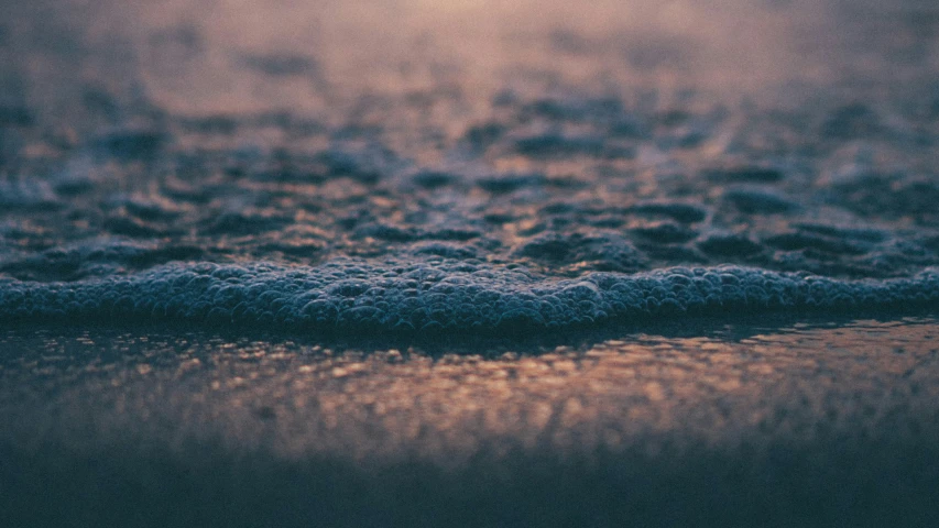 a close up view of a light shining on the sand