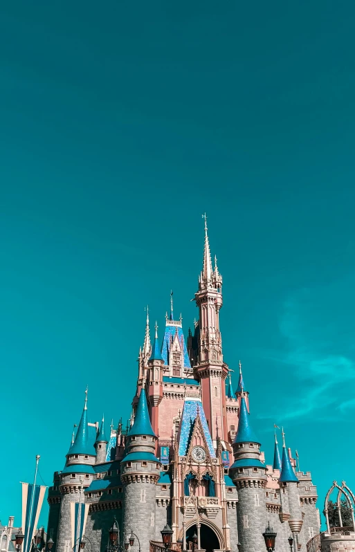 a big pink castle in front of some blue sky