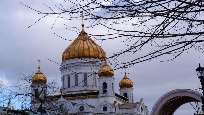 a church with golden domes sitting on the side of a building