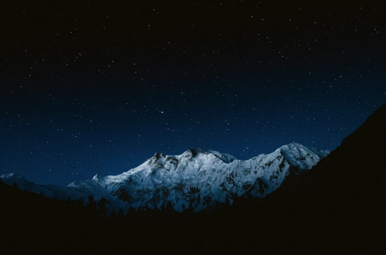 night time view of the mountains with stars in the sky