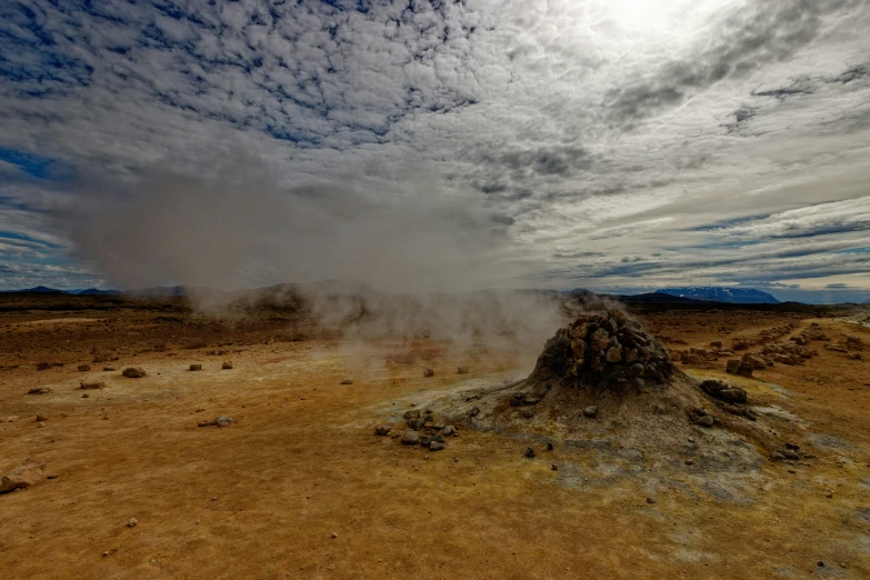 a spew of steam rising from a desert landscape