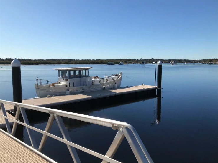 a white boat is tied up on the dock