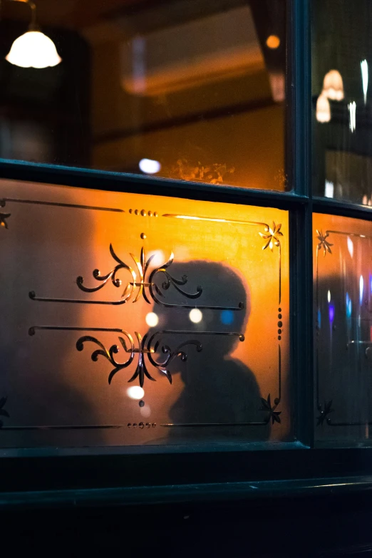 reflection on glass behind a person and a light