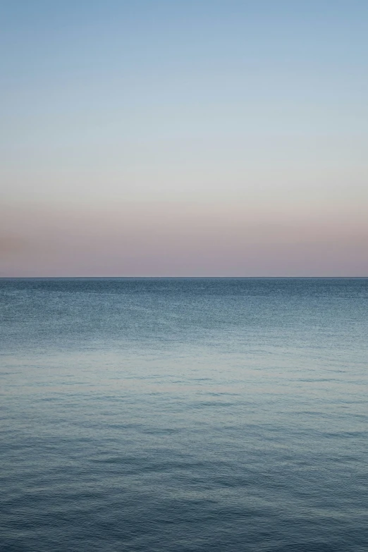 two people on a bench watching the sunset in the ocean