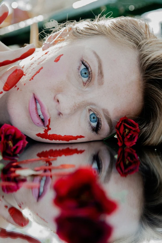 woman with makeup and flower in the reflection