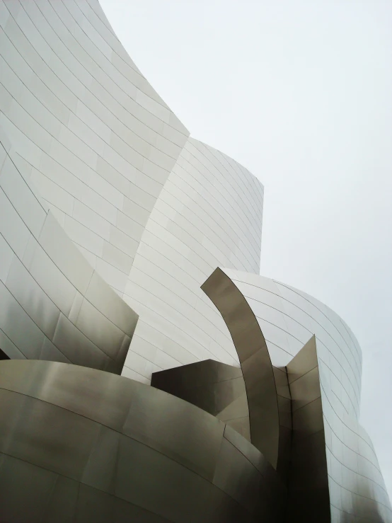 a curved building with a white facade has a long line of curved sections