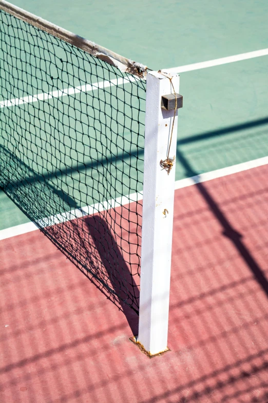 a tennis net on the tennis court with red tennis floor