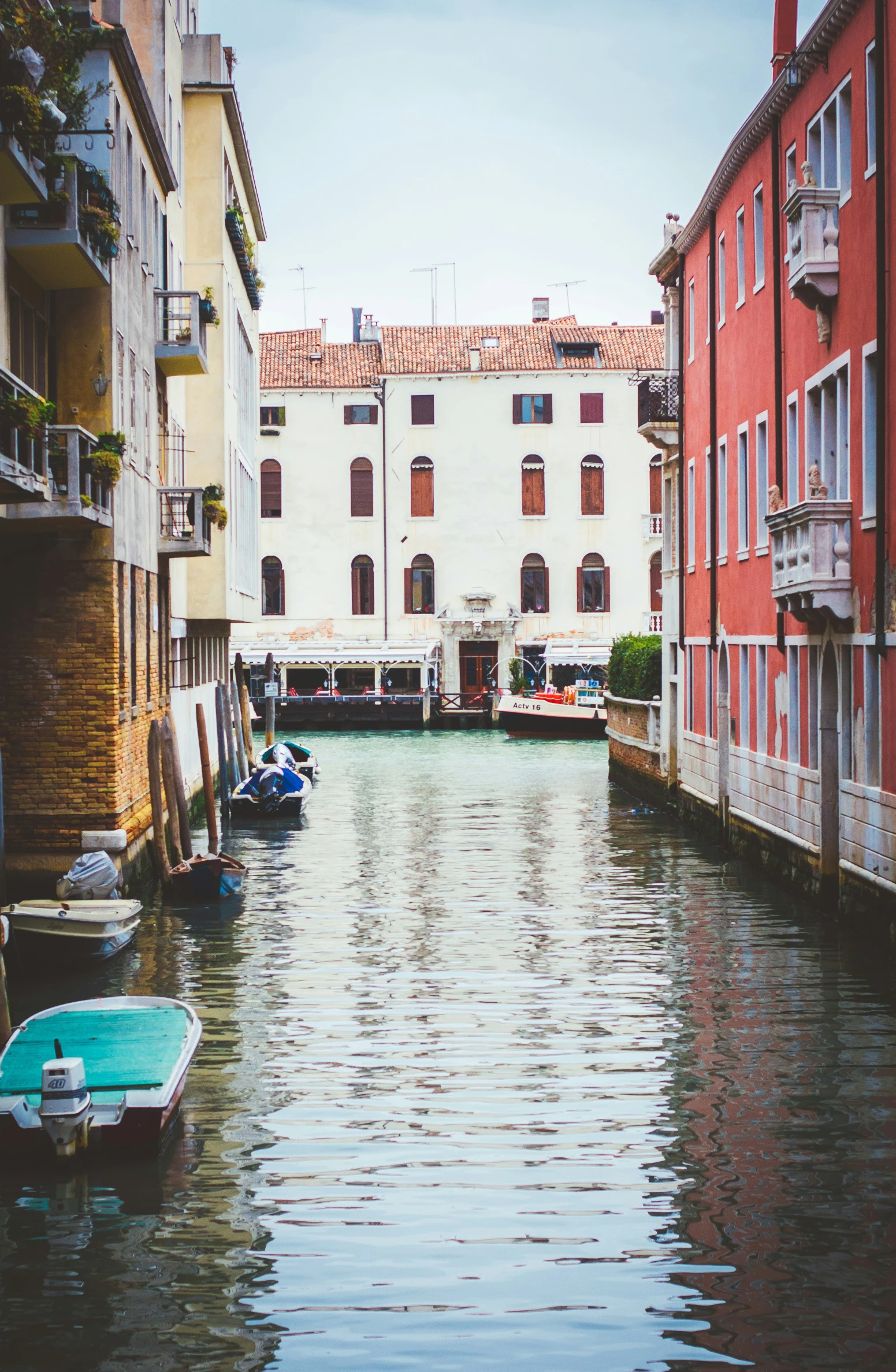 the view down a canal with small boats docked on it