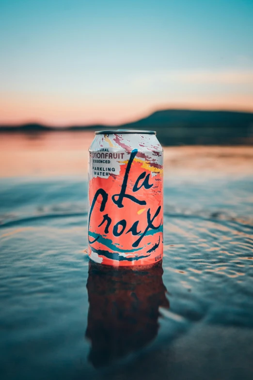 a can sitting in a lake reflecting the sun and clouds