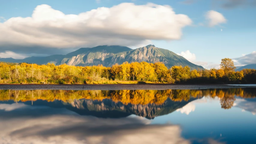 a view of a mountain and the water and clouds