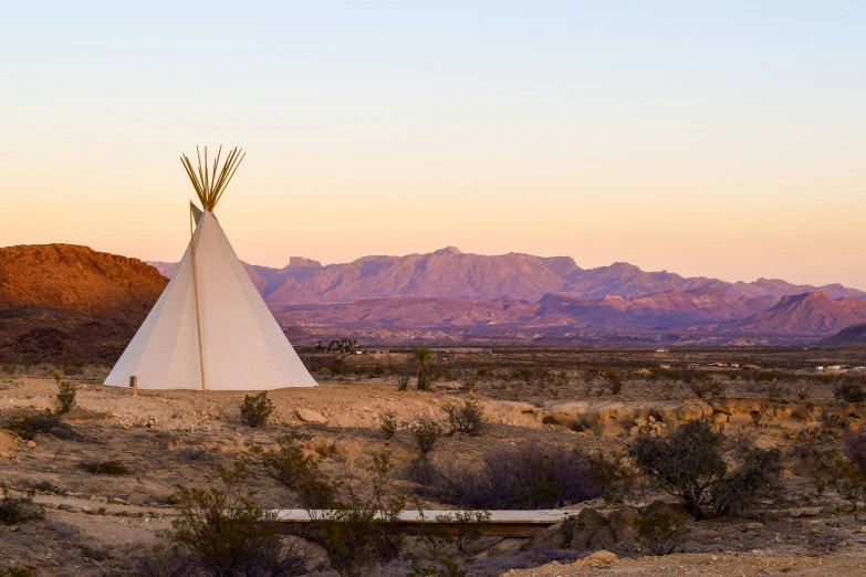 a teepee on a plain near mountains