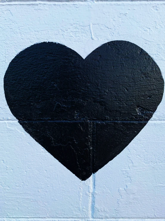 there is a black heart on a white wall