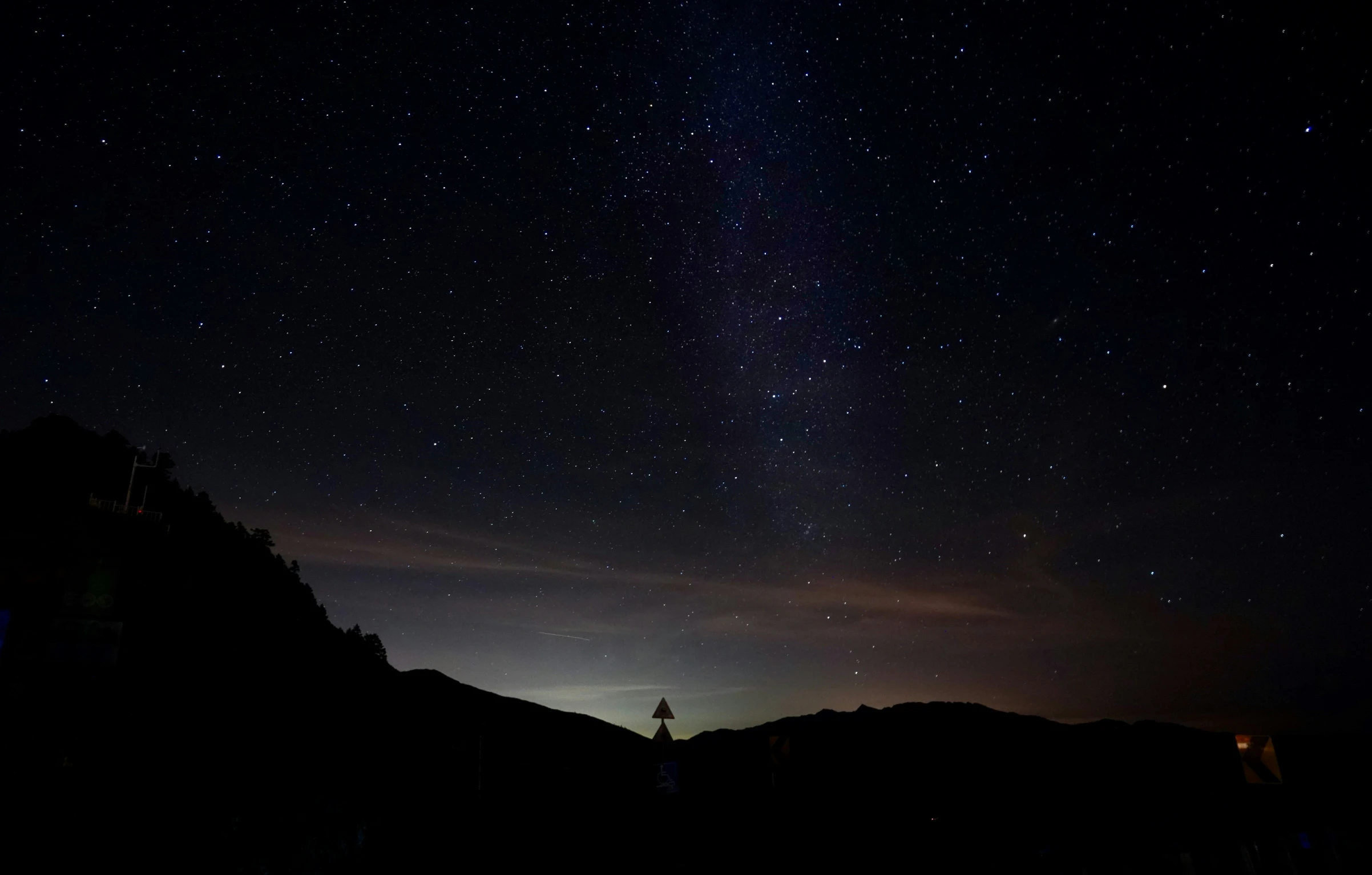 a person standing on the side of a road under a dark sky