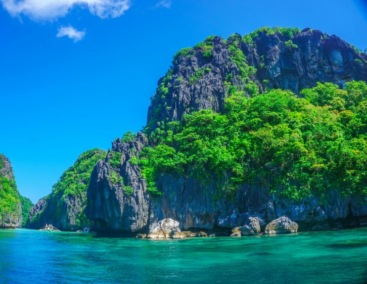 a mountain rising over the green waters of an ocean