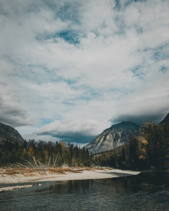 clouds gather over a mountain range with a body of water