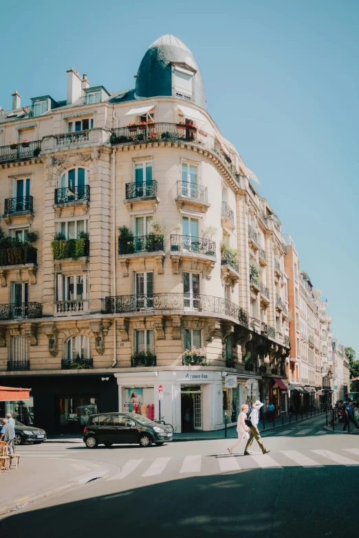 a tall building sitting next to a street with people crossing it