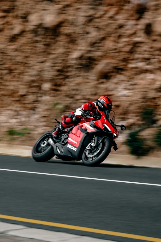 a man riding on the back of a red motorcycle