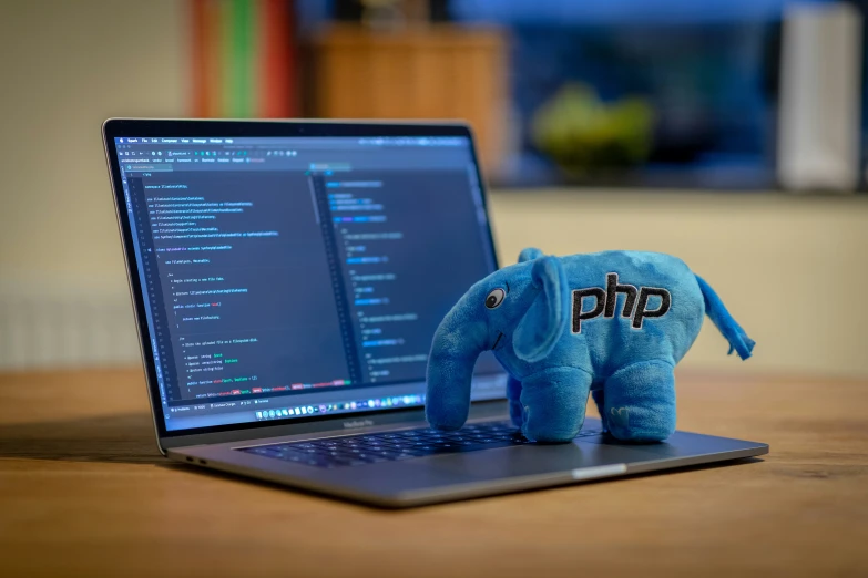 an elephant toy sitting in front of a laptop computer