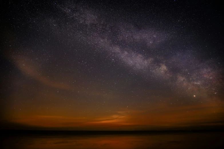 a person on a boat watching the stars over the water