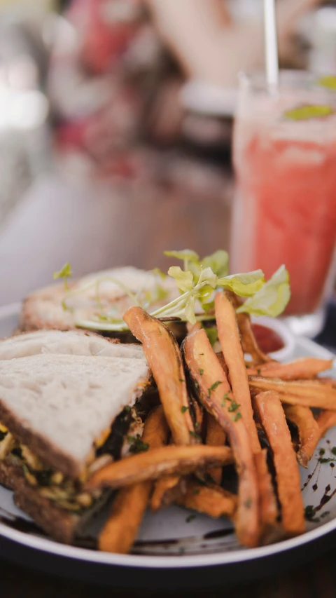 a plate with french fries, a sandwich and a soda