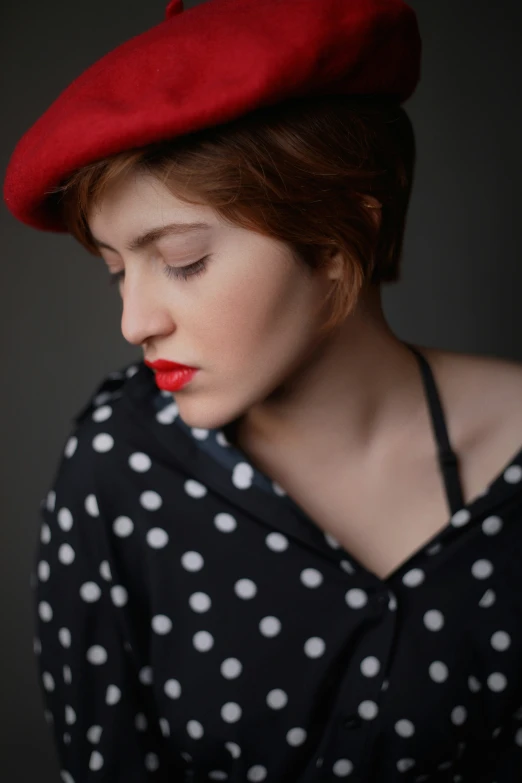 a woman wearing a polka dot dress and red hat