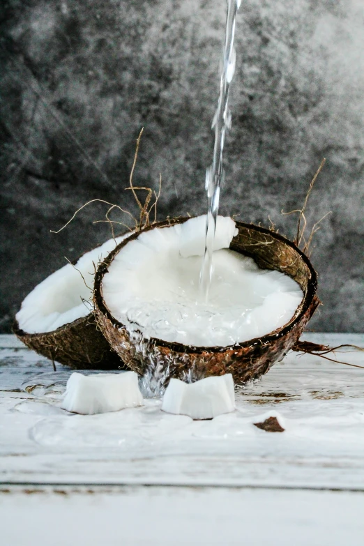 a small waterfall of water from a coconut into a bowl