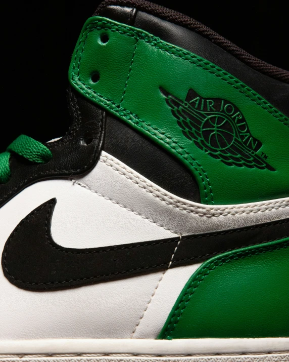 a green and black shoe with a logo on the top of it