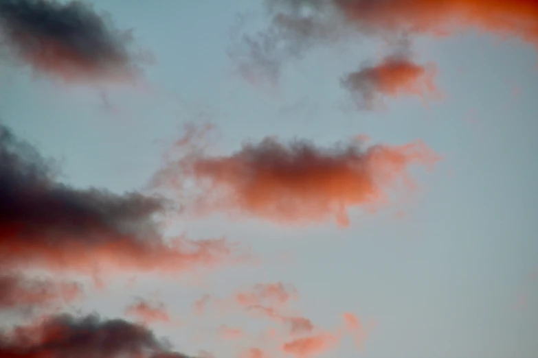 clouds are reflected in a sky with orange hues