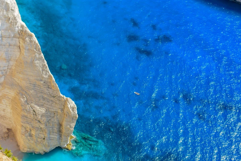 two people swimming in the ocean off of cliffs