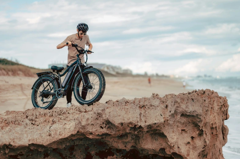 a man is riding a mountain bike on the beach