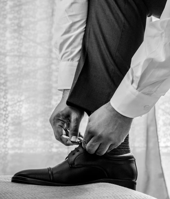 black and white pograph of someone tying shoes