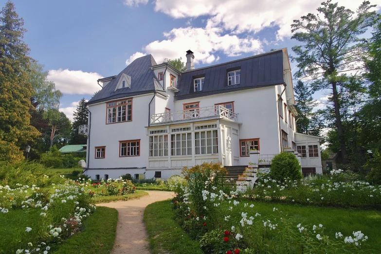 a white and red house sitting in the middle of a lush green yard