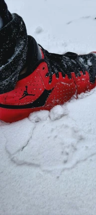 there is snow falling off the top of a sneaker