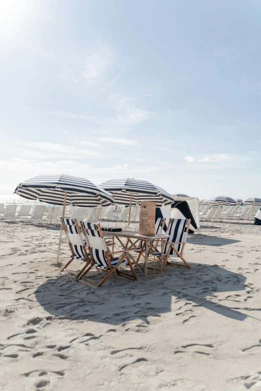 a wooden table and chairs sitting on the beach