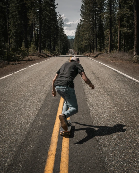 a man in a black shirt is skateboarding down the street