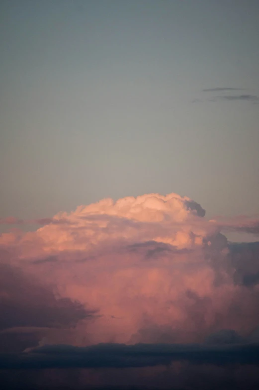 a large airplane flying high above some clouds