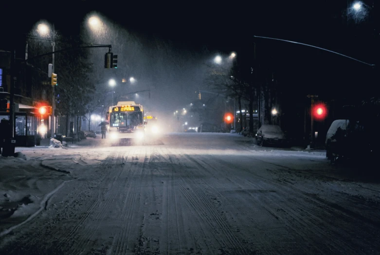 a school bus drives down a snowy street at night