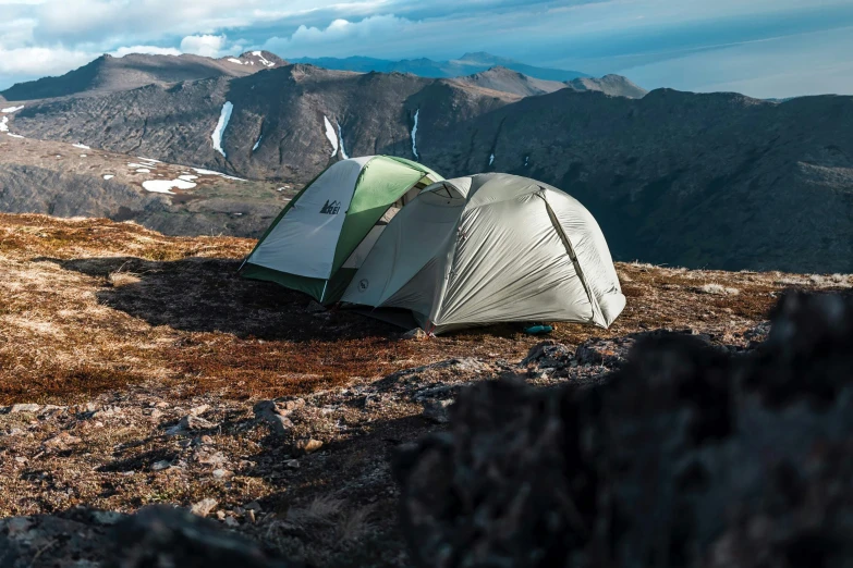 two tents are set up at the top of a mountain