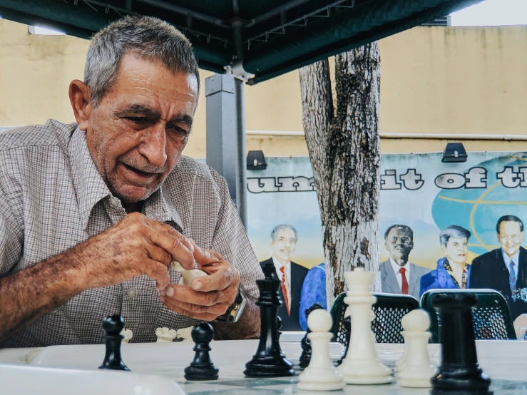 a man standing next to a chess set