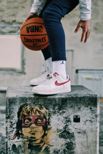 the foot of someone wearing glasses and holding a basketball