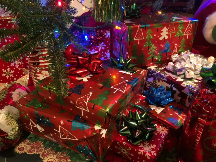 several wrapped presents stacked up with lights on them