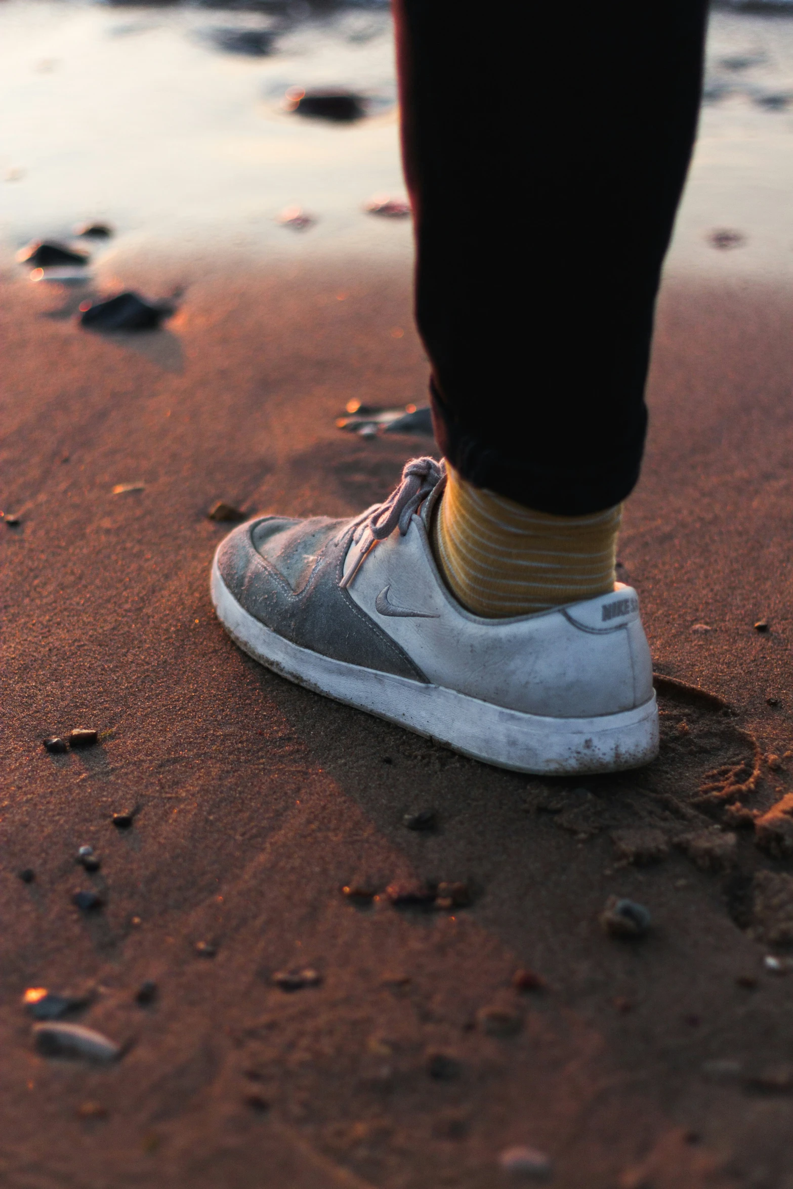 person walking along an area covered in dirt and pebbles